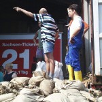 Mit Containern (Bildrand rechts) werden ständig mehr Sandsäcke herangefahren