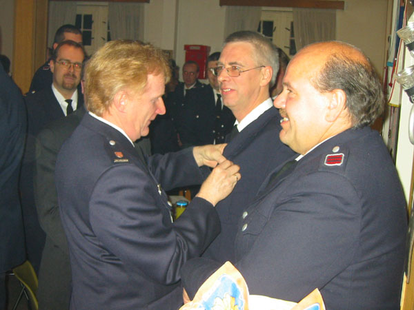 Werner Sannmann (Direktionsbereichsführer Ost-Süd) steckt Jens Albers die Auszeichnung an. Rechts im Bild: Bernd Johannsen