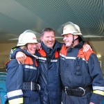 Britta und Jan nehmen den Wehrführer in die Mitte und freuen sich über den Gewinn
