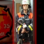 Stimmt. Wie ein Feuerwehrmann. Nur ist dies ein Modell eines Feuerwehrkameraden. Aber warum steht dieses Modell in einer Haspa-Filliale?