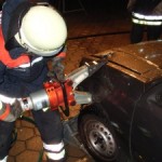 Der Kotflügel wird mit dem Spreizer zusammengedrückt. Es entsteht ein Spalt, so dass man an die Schaniere der Tür kommt.