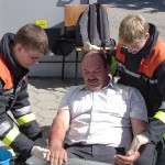 Andre Voß und Malte Kantak versorgen eine Person mit Brandverletzungen an beiden Unterarmen.