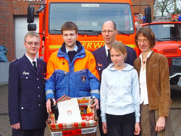 JFW Matthias Hedemann und Marcel Riese überreichen dem Jubilar einen Präsentkorb. Tochter Lara und Ehefrau Marion freuen sich mit ihm. (v. links)