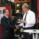 Wehrführer Fabian Keller überreicht eines der Geschenke der Wehr nach seiner Ansprache.